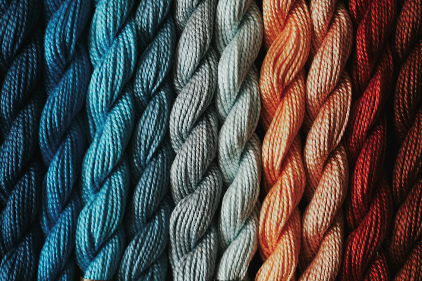 Twisted skeins of teal, grey and copper yarn